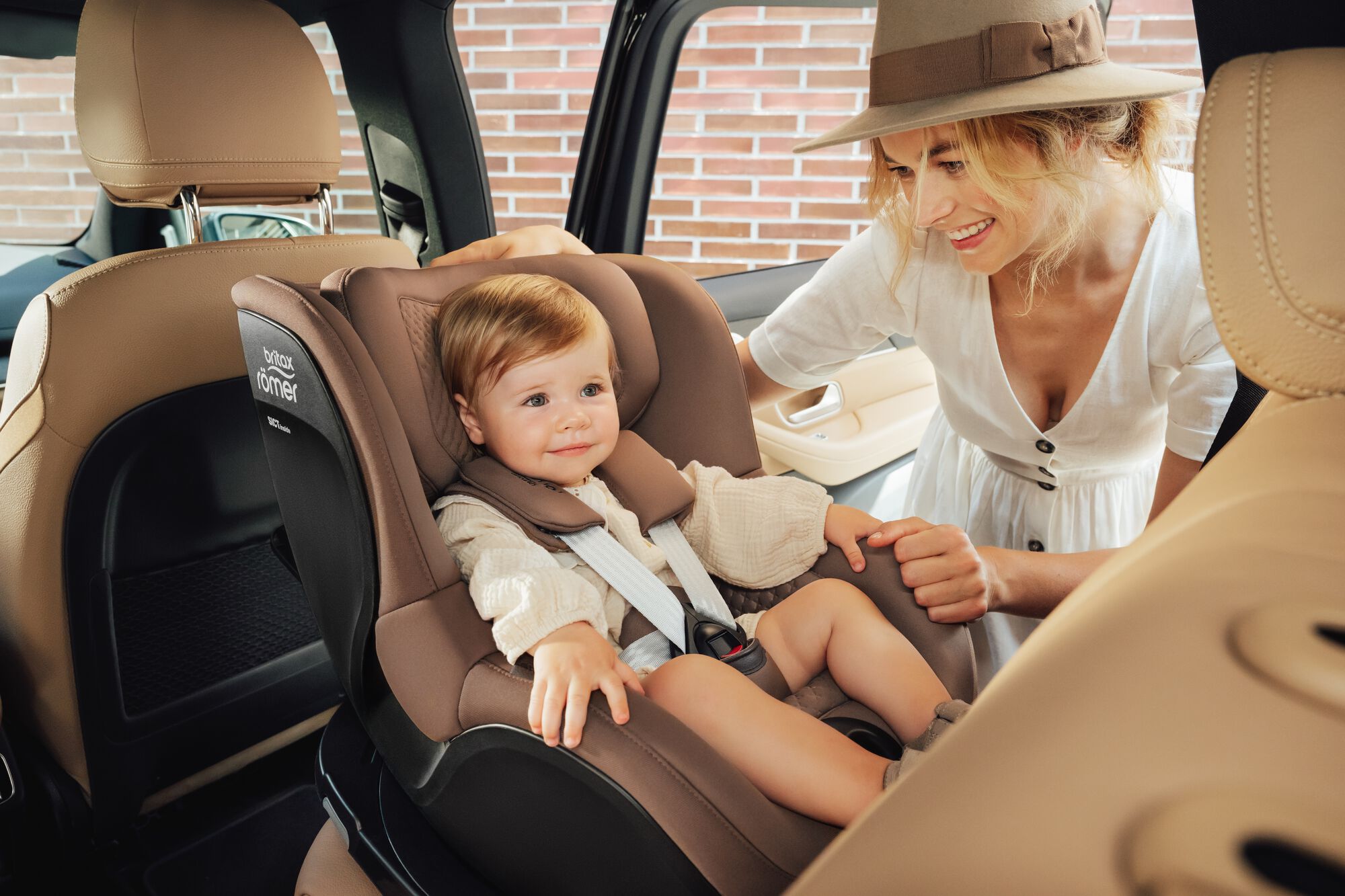 Kisgyermek DUALFIX 5Z toddler car seat autósülésben rögzítve, édesanyja mellette áll.